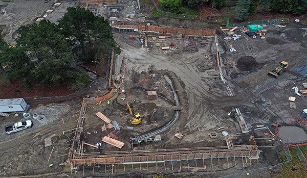 aerial view of construction site with a curved trnecy with pipes and a concrete frames with concrete in them