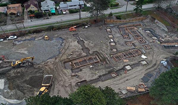 aerial view of a construction site with several rectangular holes lined with wooden frames