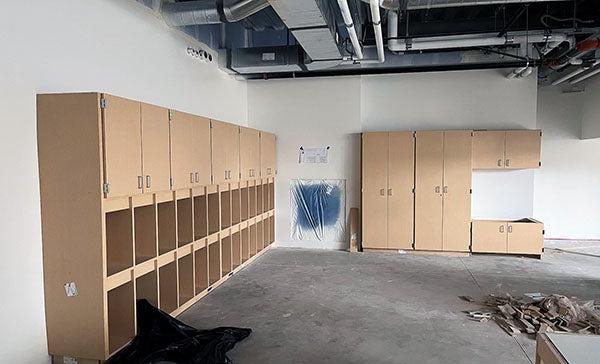 a large room with no ceiling has cabinets on two walls
