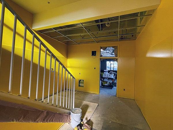 a yellow hallway with a stairway